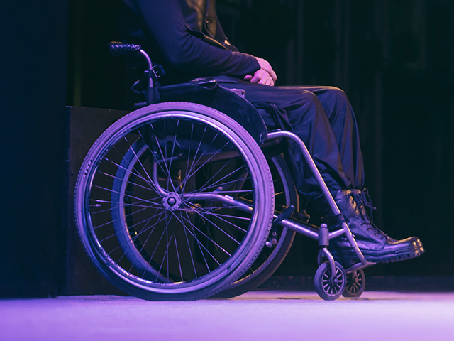 person in a wheelchair on a dark background