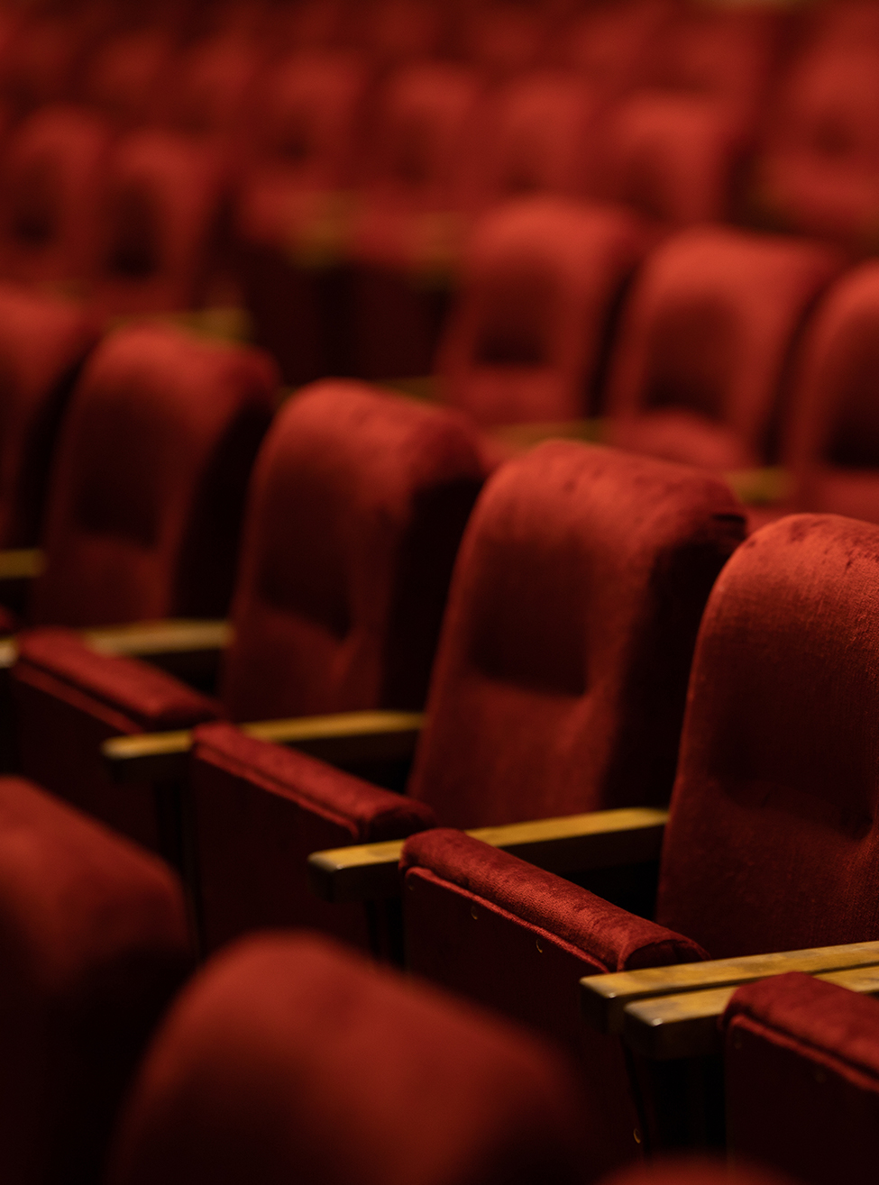 empty red velvet seats in a theatre