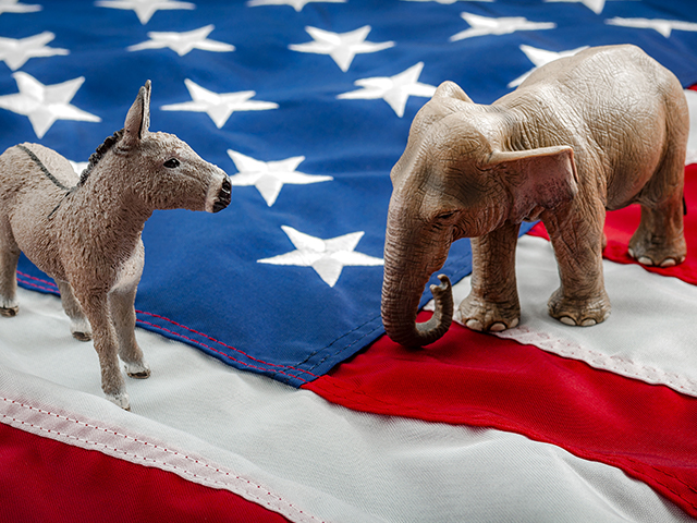 donkey figure and elephant figure (The symbols of the Democratic Party and the Republican Party) placed on top of an american flag