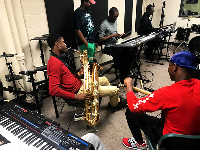 Students in music studio with different instruments