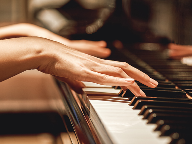 Close up view of gentle female hands playing piano