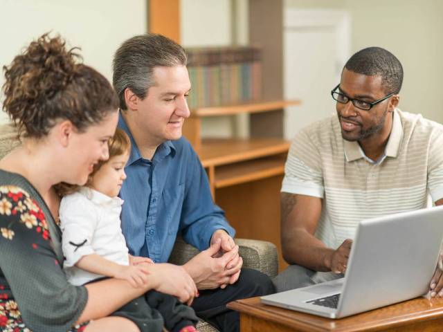 Social worker working with a family at a computer