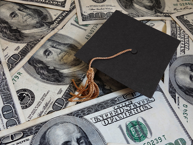 Graduation cap sittting on top of money