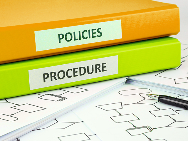 Company policies and procedures lables on orange and green document binders