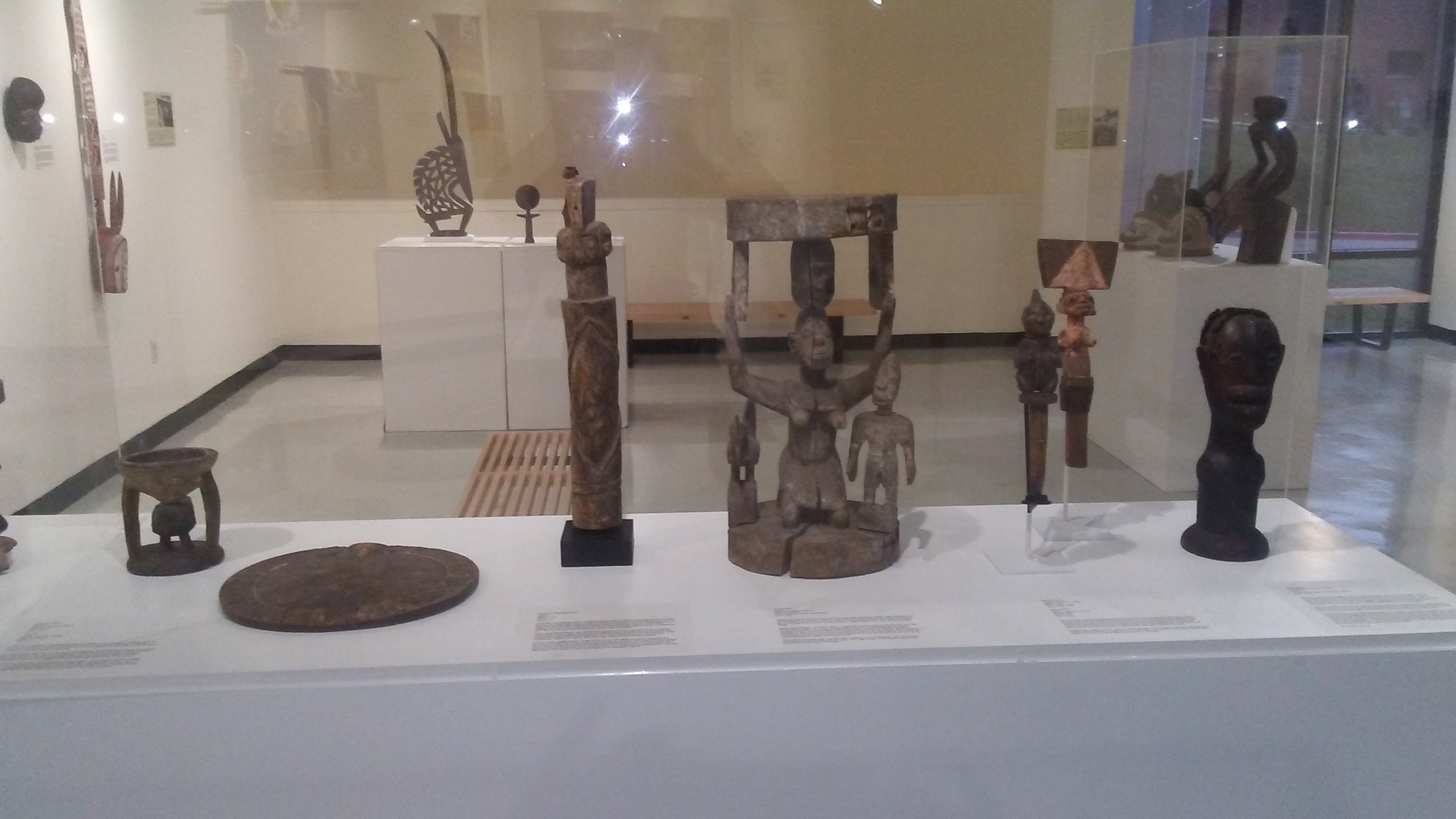 a grouping of small African sculpture in an exhibition case