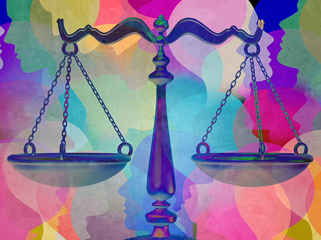 Legal justice scales in front of colorful background illustration of diverse head shaped cut outs