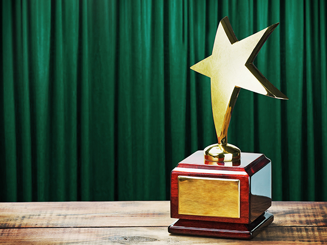Star award wooden table and on the background of green curtain